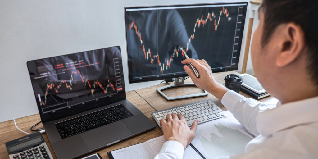 Image of a man analyzing a chart on his desktop computer