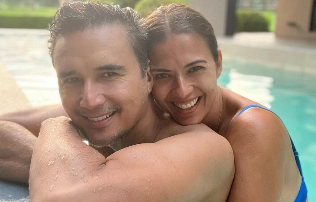 Priscilla Meirelles hugs her husband, John Estrada, from the back as while they were enjoying a swim in the pool.